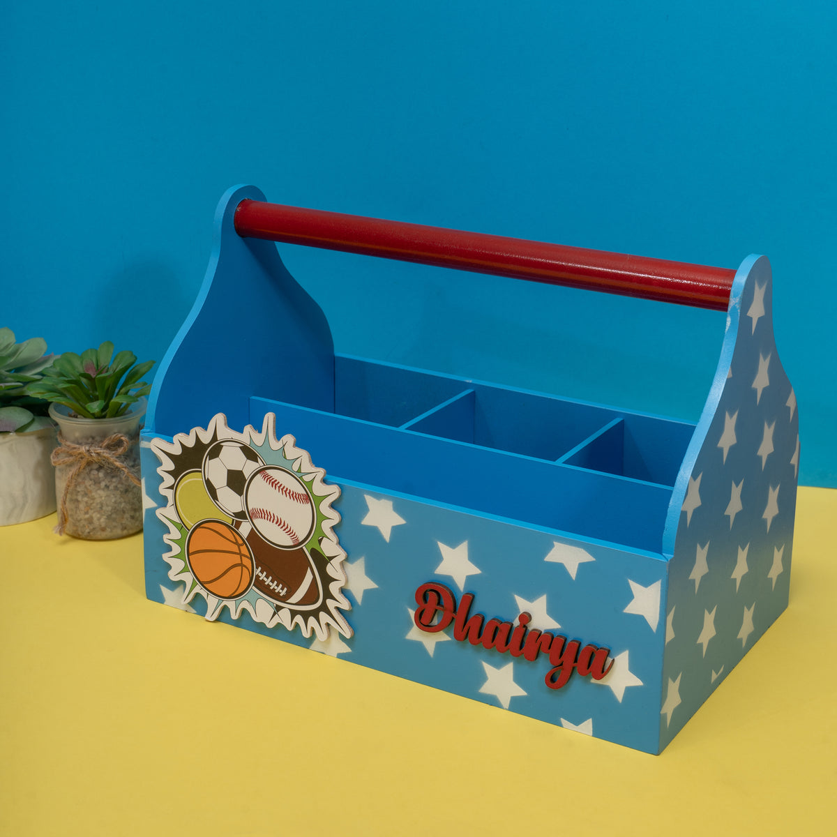 Blue tool caddy with sports-themed design and 'Dhairyaa' branding on a yellow surface with blue background