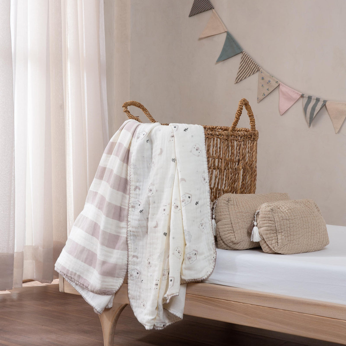 Nursery room with wooden crib, plaid blanket, and decorative flags on a beige wall.