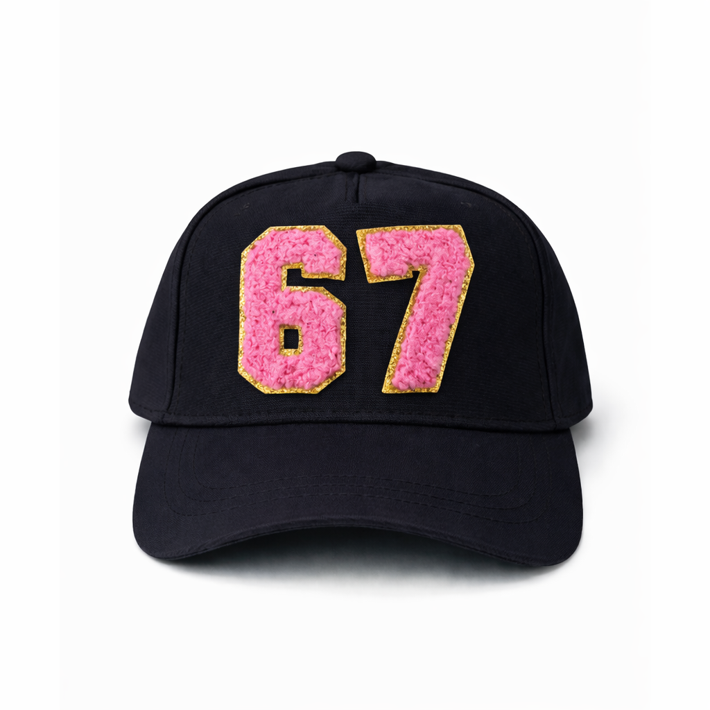 Black cap with pink and gold number '67' on a white background