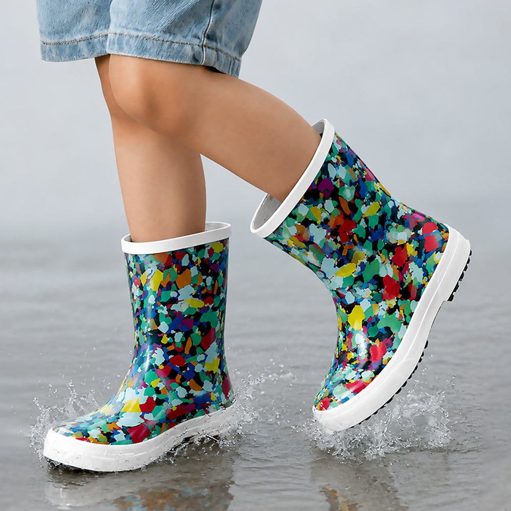 Colorful patterned rain boots being worn on a wet surface