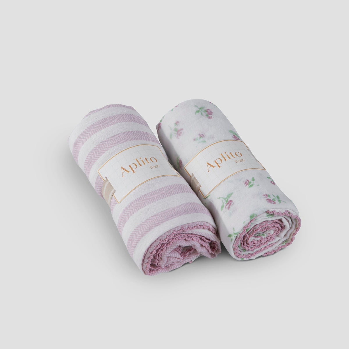 Two rolled-up baby blankets with floral and striped patterns on a white background