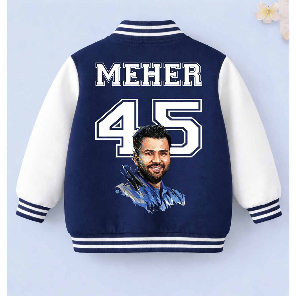 Navy blue personalised cricket varsity jacket with “MEHER 45” printed on the back against a light blue background.