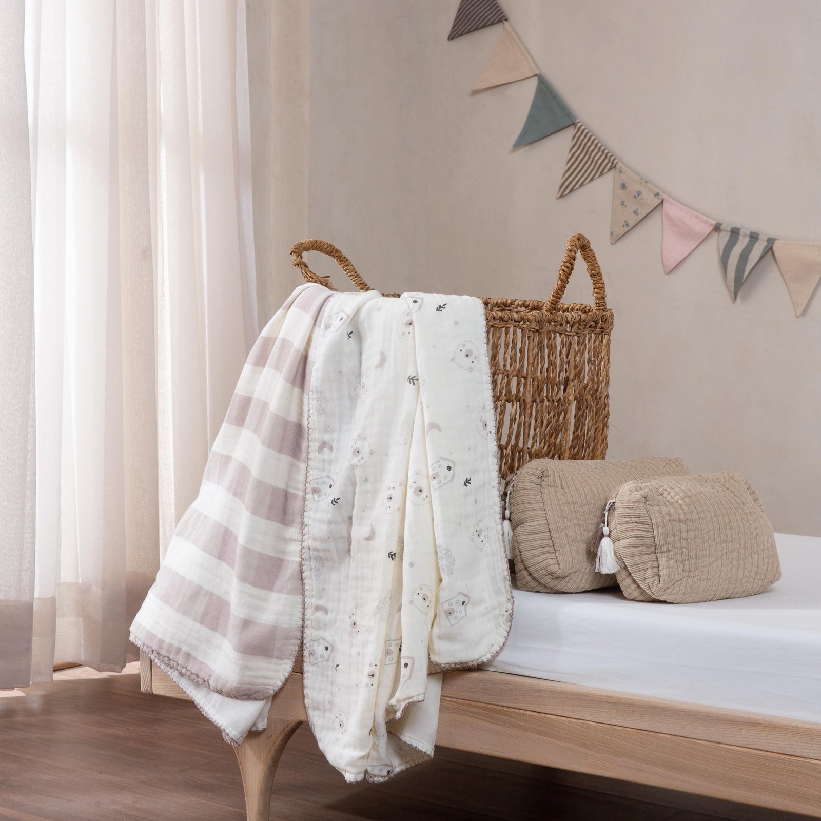 Nursery room with wooden crib, plaid blanket, and decorative flags on a beige wall.