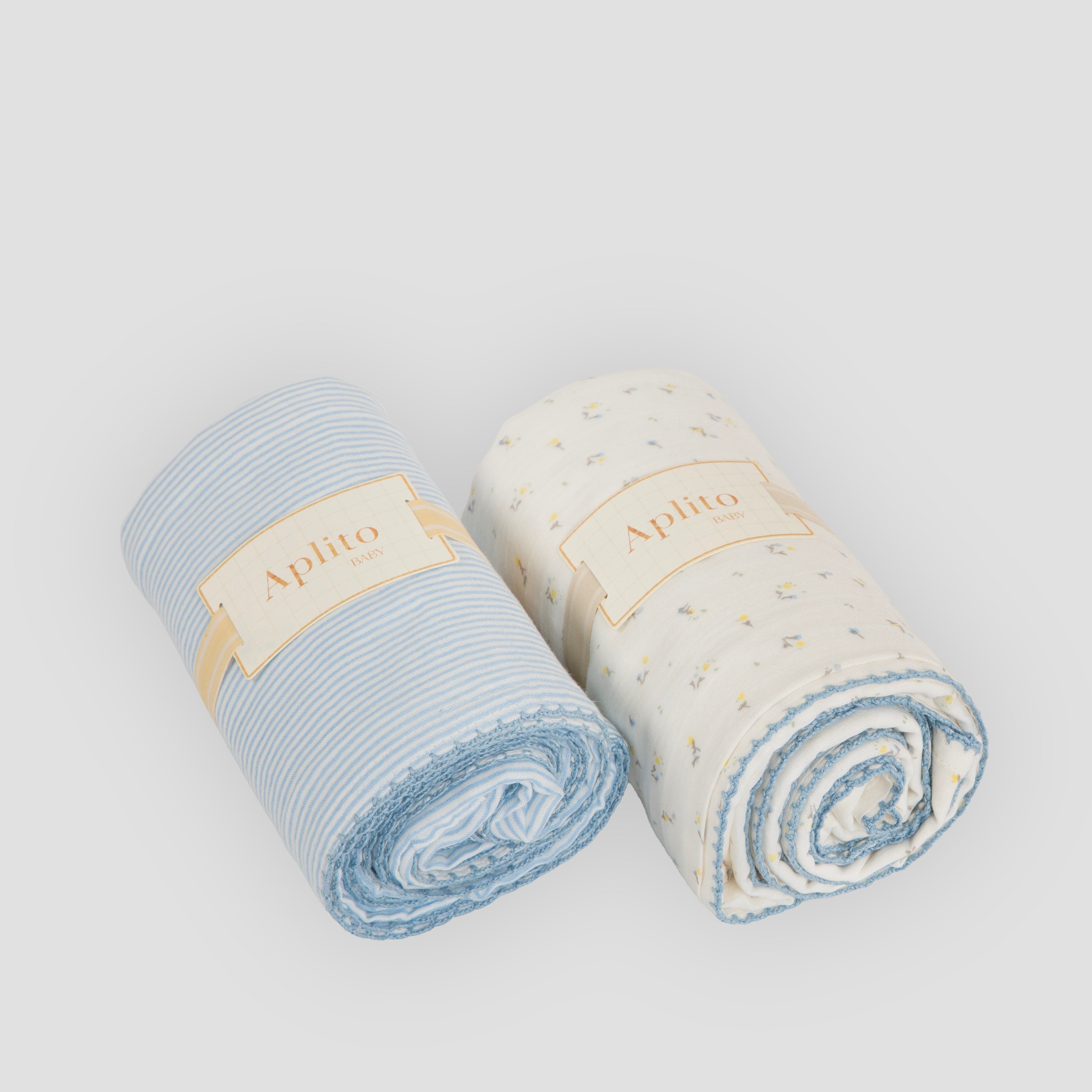 Two rolled-up towels, one blue and one white with blue accents, on a light gray background.