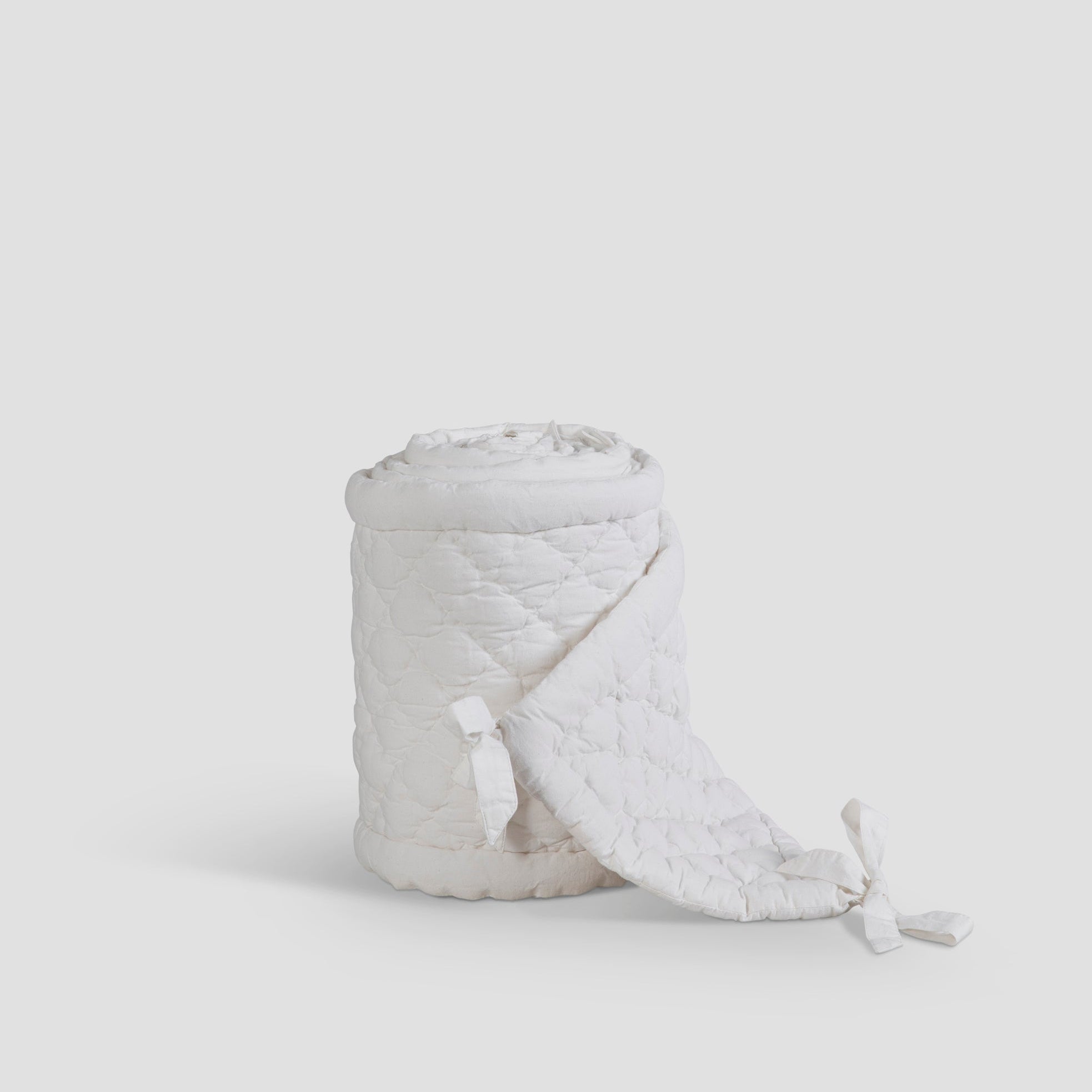 White textured basket with a handle on a light gray background