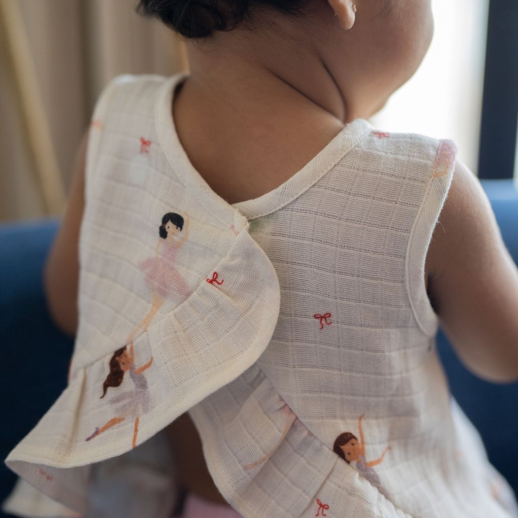 Child wearing a dress with ballerina designs on a blurred background