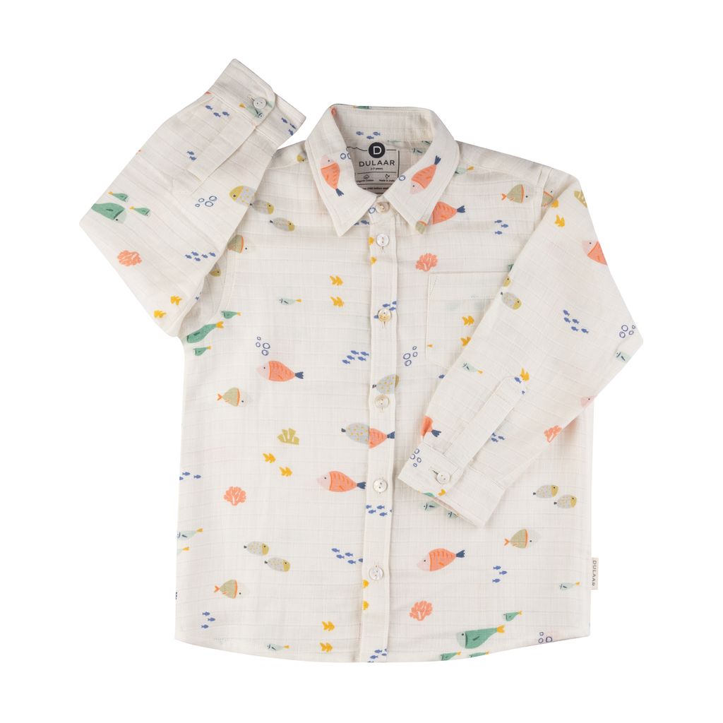 White long-sleeve children's button-down shirt featuring an all-over colorful fish and underwater print, with a classic collar, front button closure, and chest pocket, displayed on a light background.