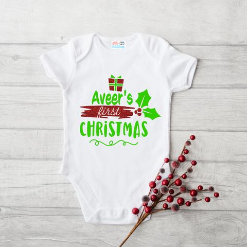 files/LH_FirstChristmas_Gift_Leaves_WhiteOnesie_GreenRedGlitter.png