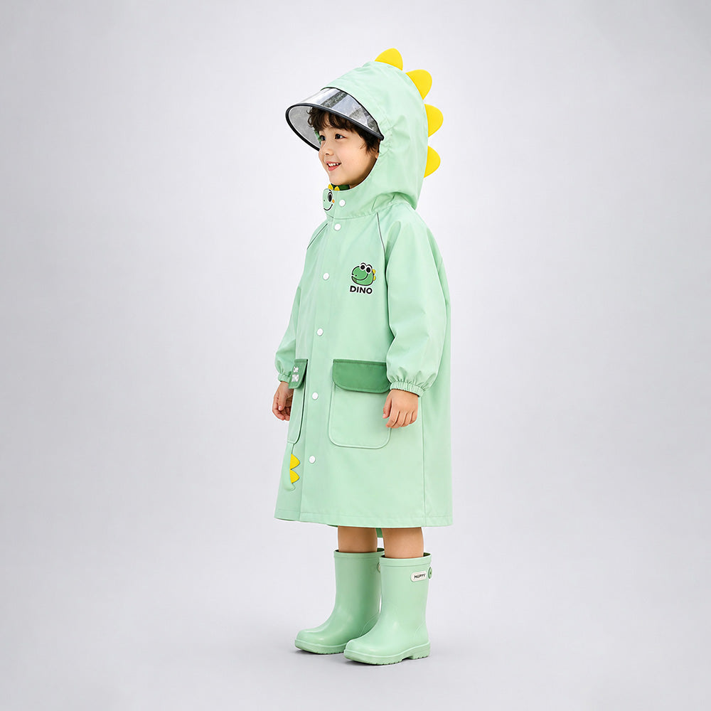 Child wearing a green dinosaur-themed raincoat and boots on a white background