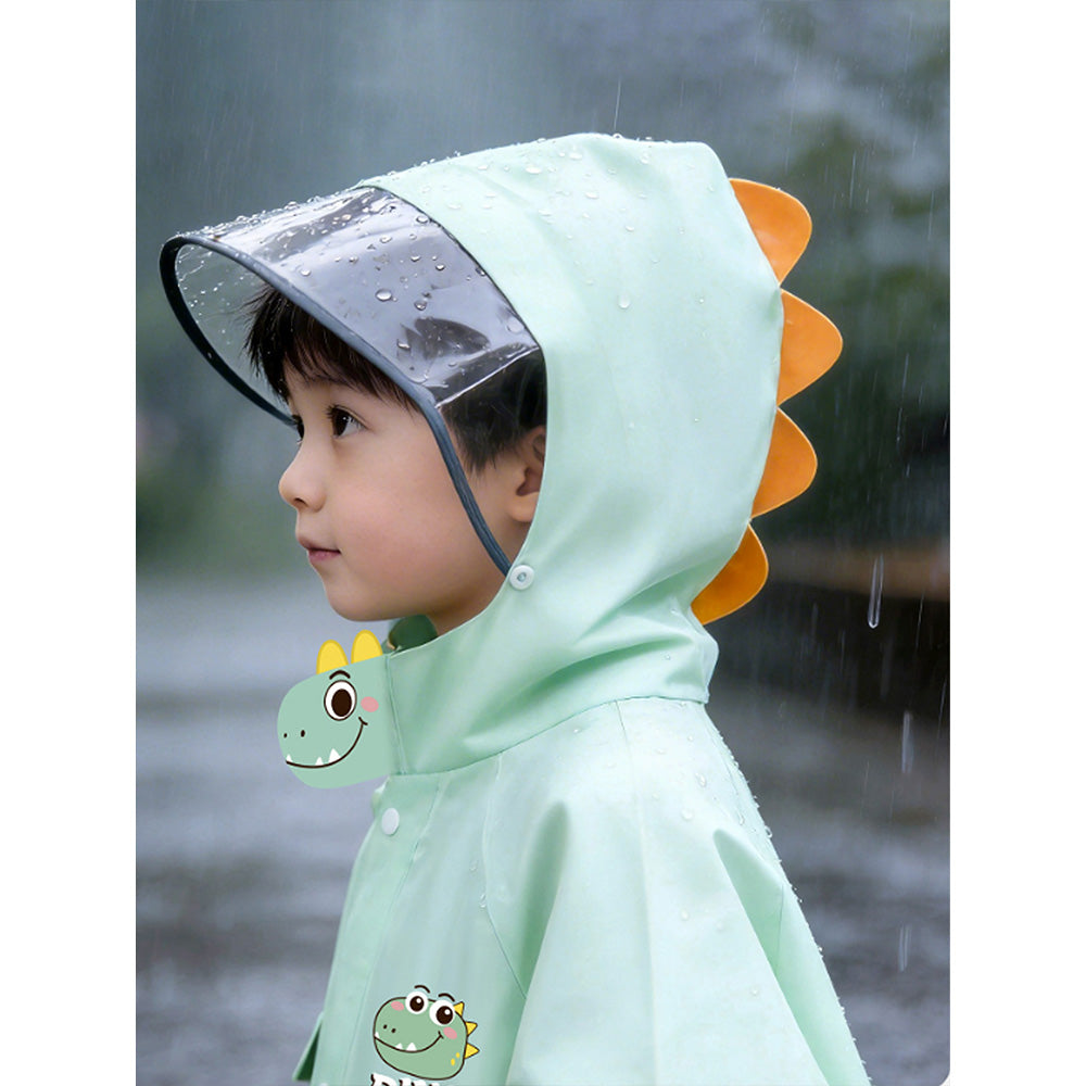 Child wearing a light green raincoat with dinosaur design in the rain