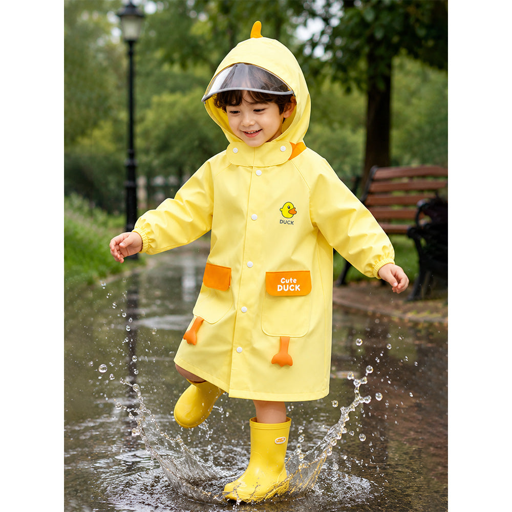 Child wearing a yellow raincoat with duck design, splashing in a puddle outdoors.