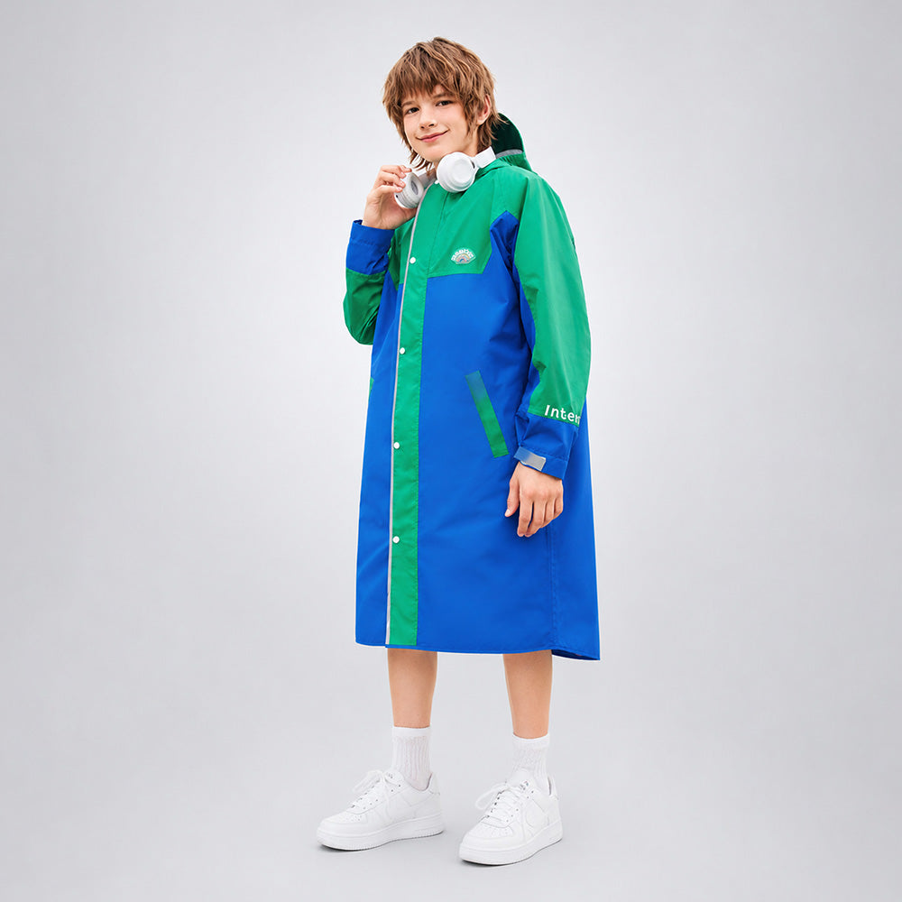 Person wearing a blue and green raincoat on a gray background