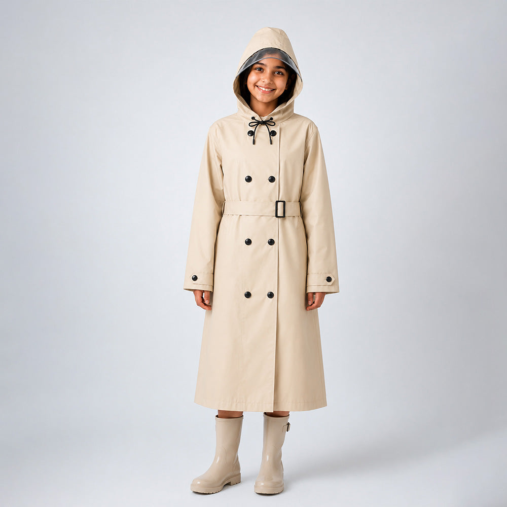 Person wearing a beige trench coat with black buttons on a white background