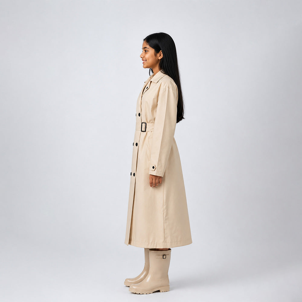 Woman wearing a beige trench coat and boots on a white background
