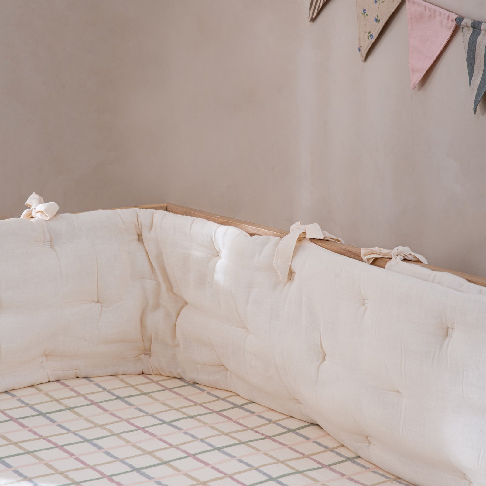 Crib with white mattress and decorative flags on a wall