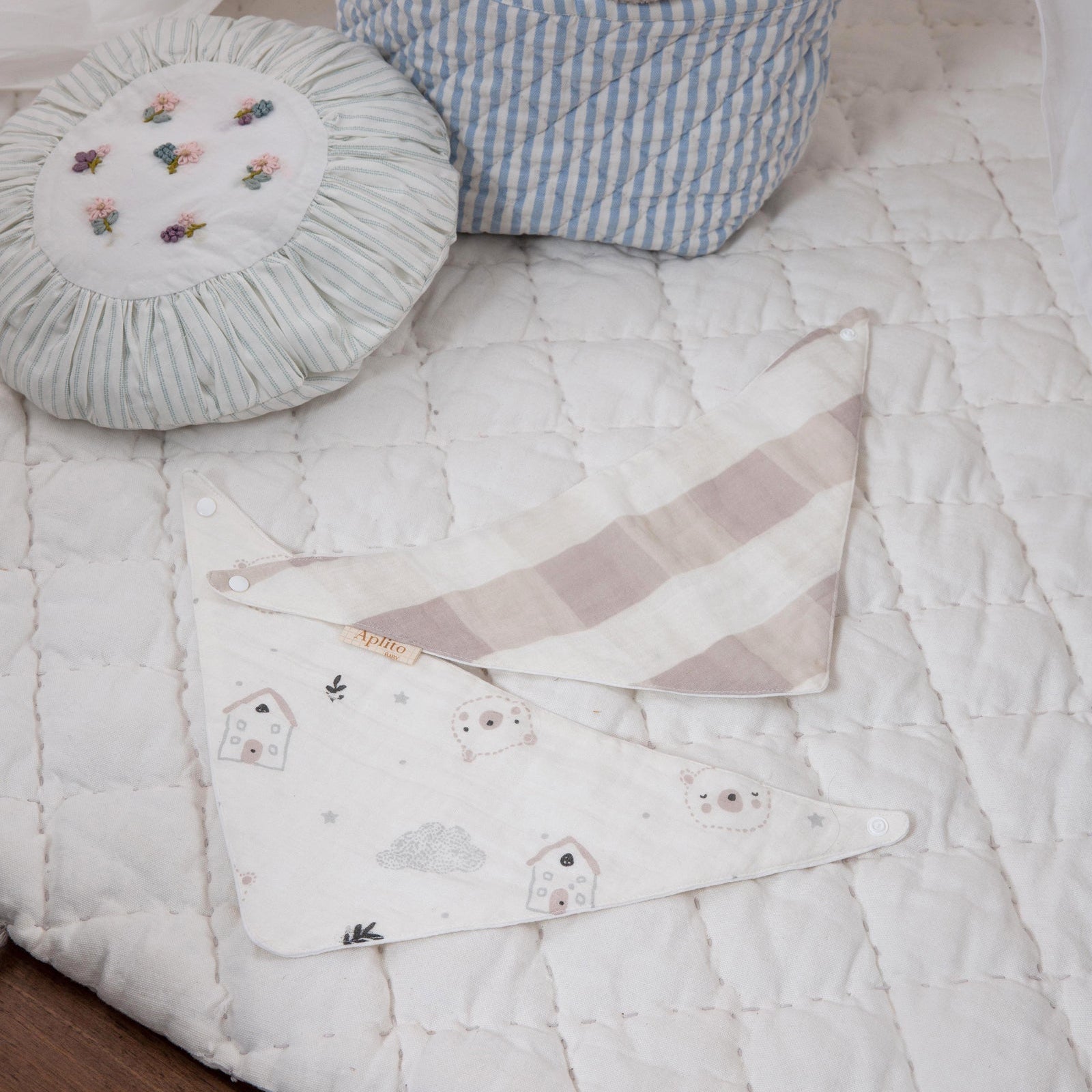 Children's room with a quilt, basket of toys, and decorative pillow.