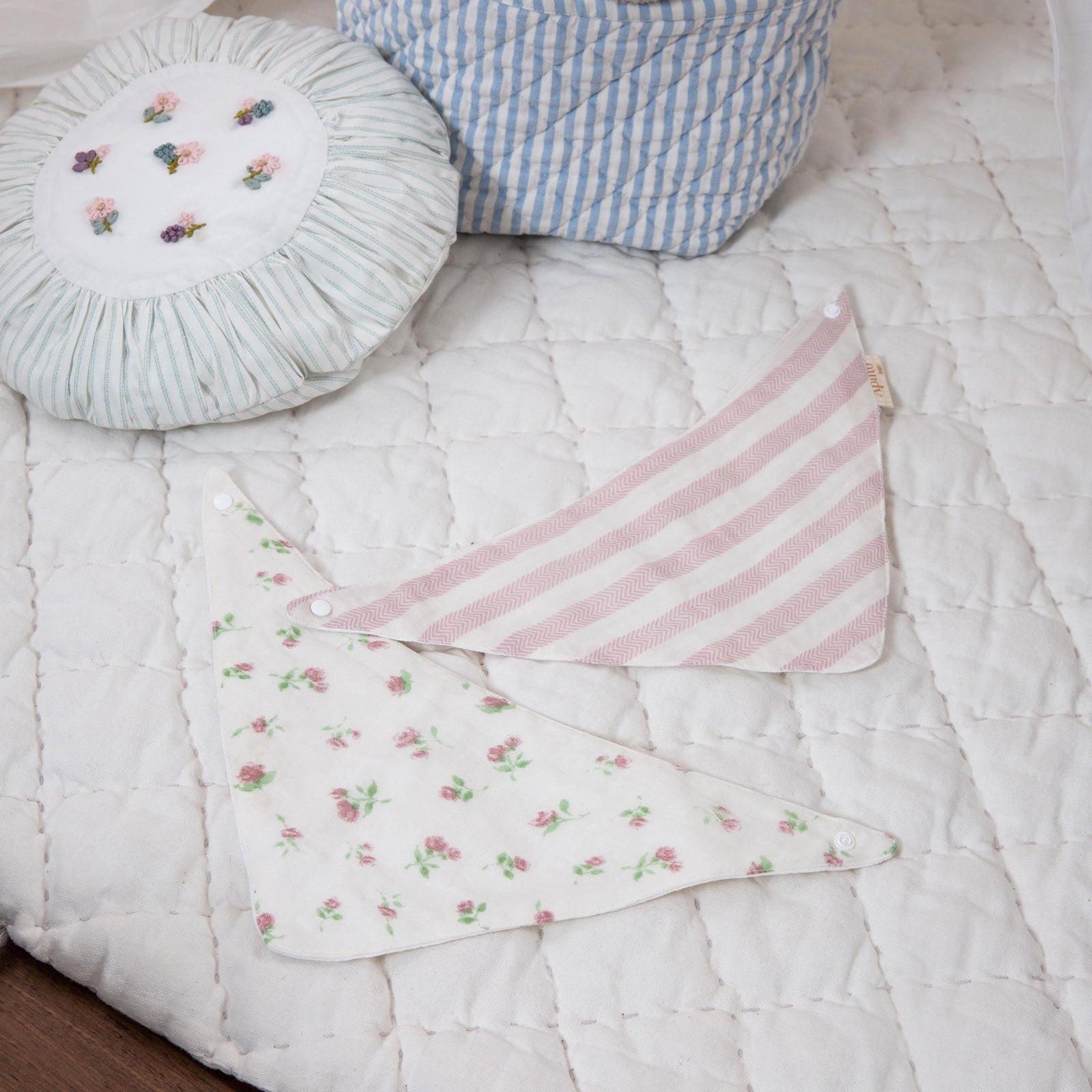 Children's bedroom with a basket of toys, pillows, and a blanket on a bed.