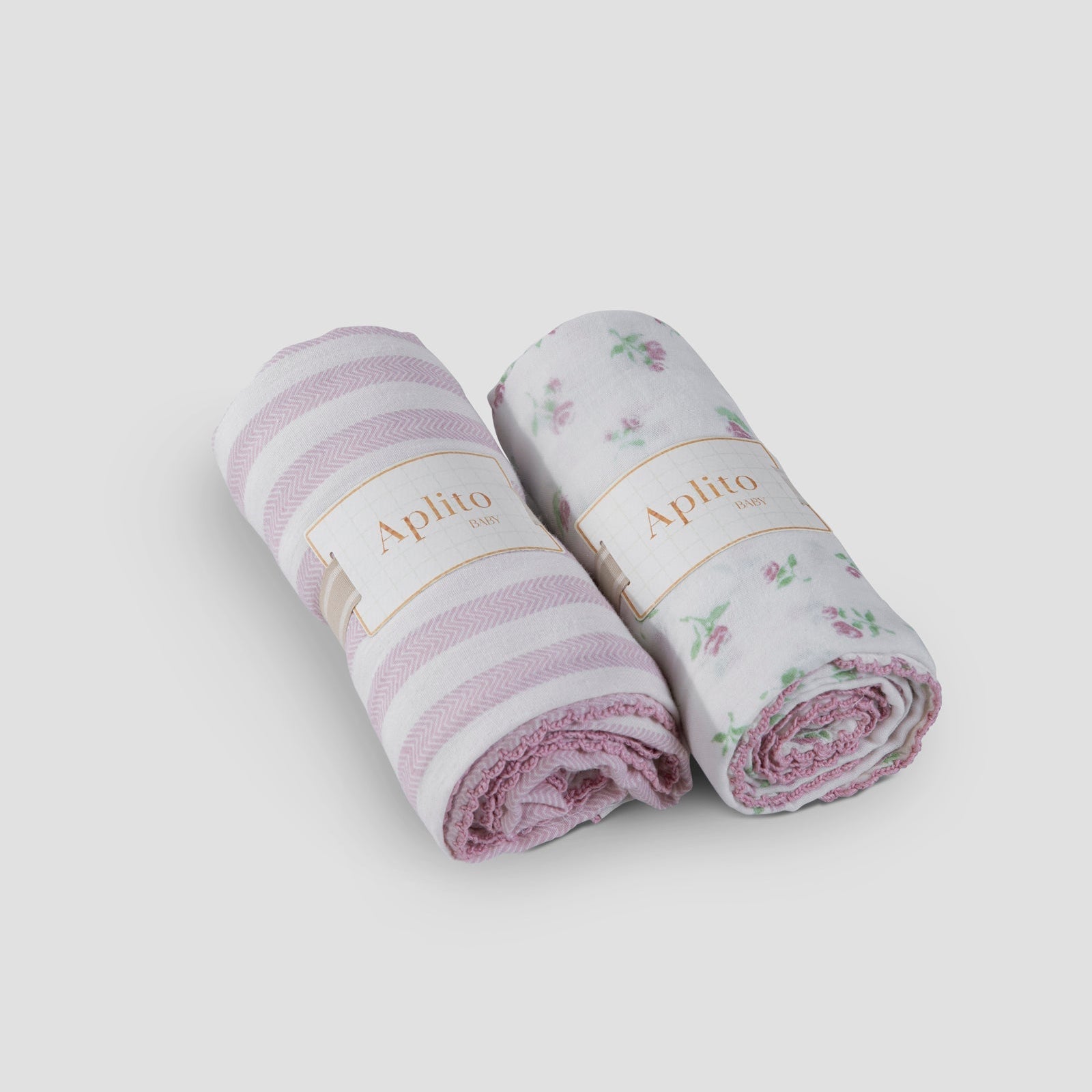 Two rolled-up baby blankets with floral and striped patterns on a white background