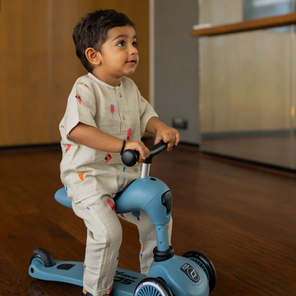 Child riding a blue scooter indoors