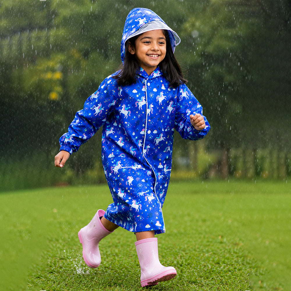 Child running outdoors in navy unicorn print kids raincoat during rain