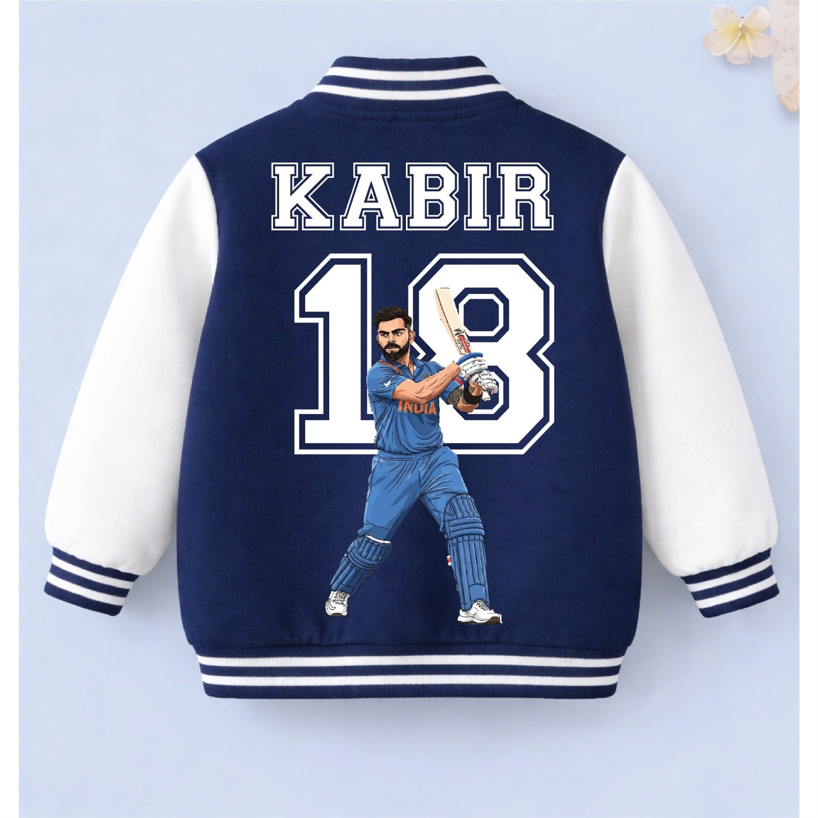 Navy blue and white personalised cricket varsity jacket with cricket player illustration and “KABIR 18” printed on the back.
