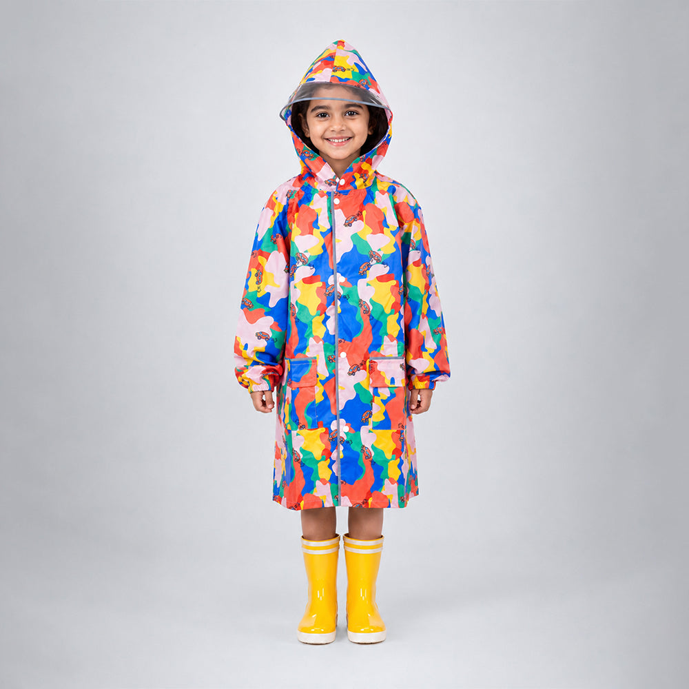 Child wearing pink color pop knee-length raincoat with hood, clear brim and yellow rain boots